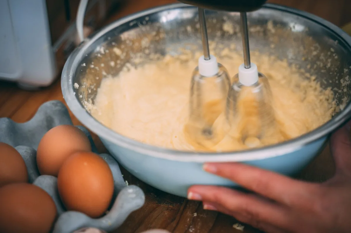Massa de bolo sendo preparada com ingredientes sobre a mesa
