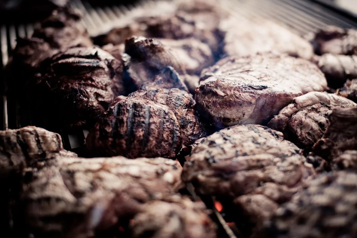 Carnes sendo grelhadas na churrasqueira