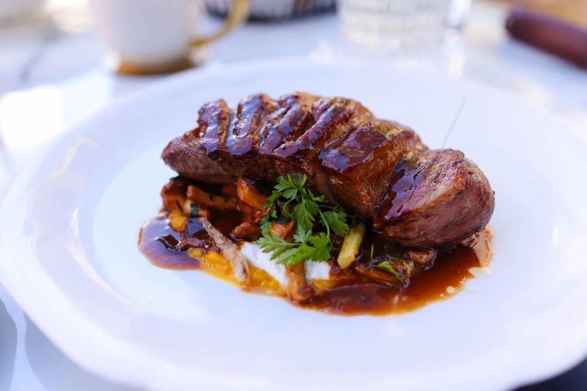 Carne dourada sendo preparada em frigideira quente