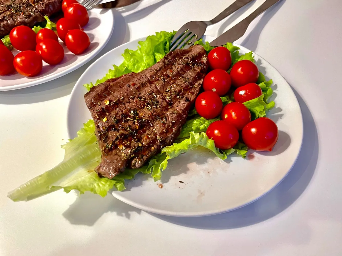Bife sendo frito na frigideira com óleo quente