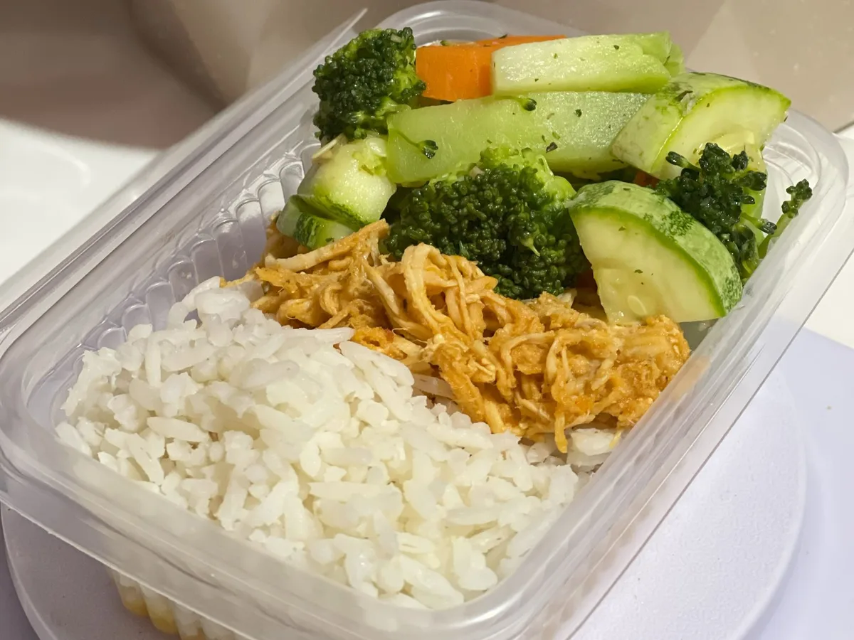Tigela com arroz branco cozido e legumes coloridos, pronta para ser servida
