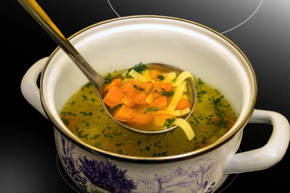 Panela de feijão cozido no fogão com caldo cremoso