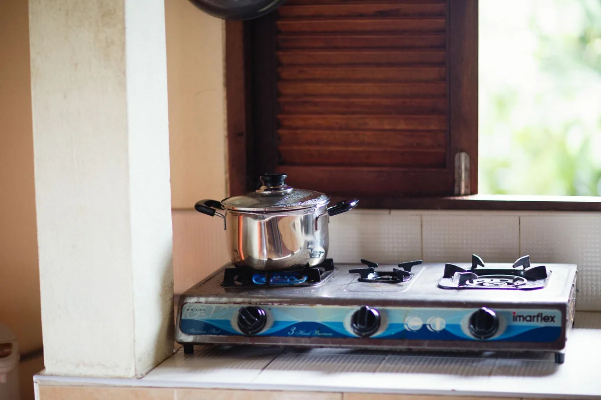Panela de inox com vapor cozinhando no fogão a gás
