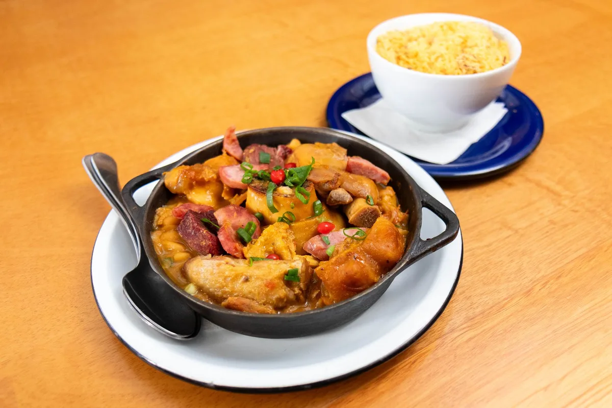 Prato de comida brasileira servido em tigela sobre mesa de madeira