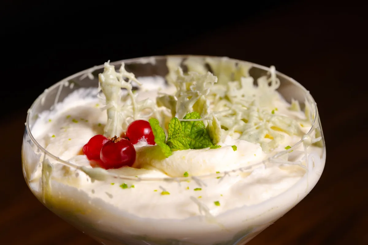 Tigela com mousse cremoso branco servido em recipiente de cerâmica