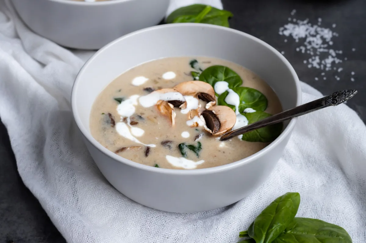 Sopa cremosa servida em tigela com colher, mostrando textura aveludada