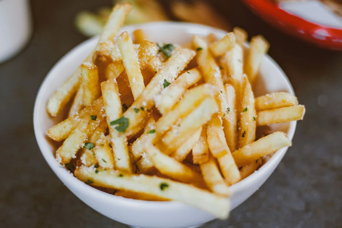 Batatas fritas douradas e crocantes servidas em prato branco