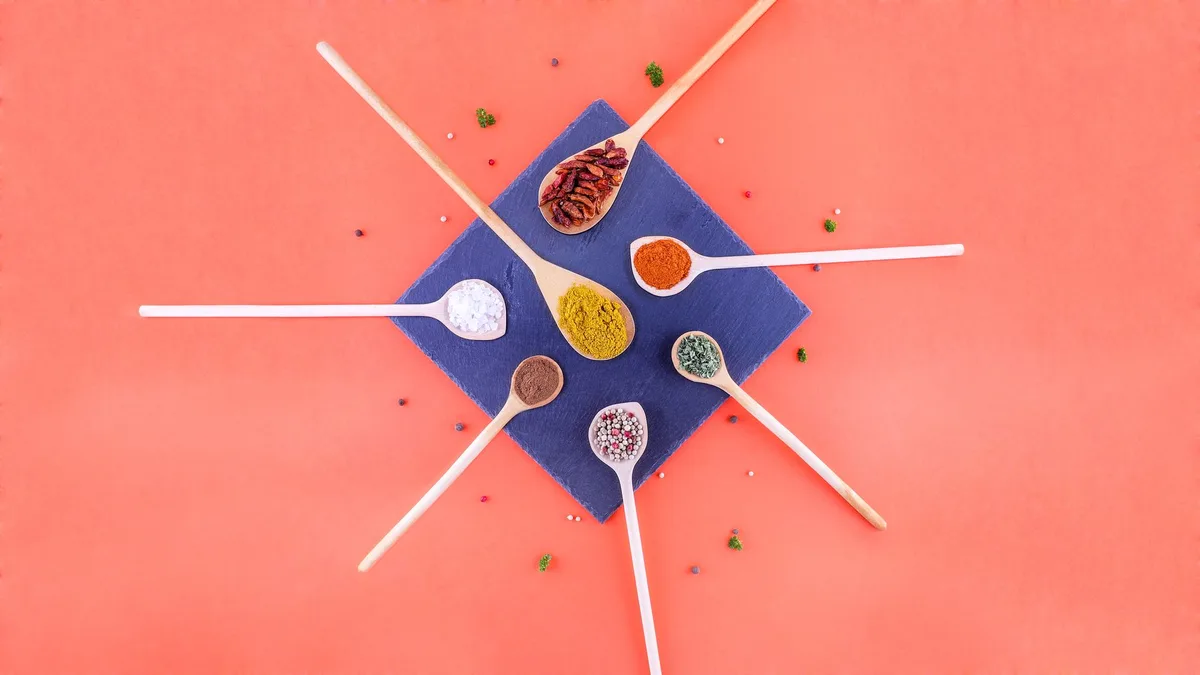 Colheres de madeira com temperos coloridos variados sobre mesa